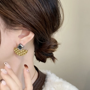 Gros plan détaillé de boucles d'oreilles géométriques en métal avec relief sur mannequin