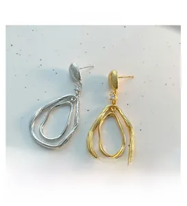Détail de boucles d'oreilles goutte avec texture coquillage et accents de zircone