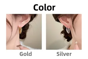 Detail of heart hoop earrings with textured finish in gold and silver color options