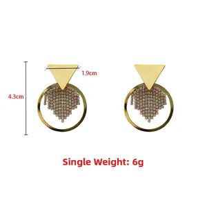 Detailansicht geometrischer Goldohrringe mit Blattmuster und Quasten aus Strass