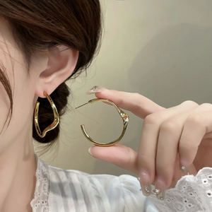 Boucles d'oreilles créoles dorées irrégulières et minimalistes avec texture polie