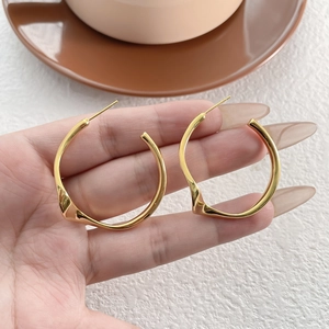 Boucles d'oreilles créoles dorées minimalistes avec design ondulé irrégulier pour femme