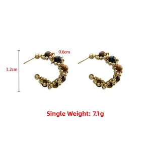 Détail de boucles d'oreilles créoles avec perles dorées et pierres œil de tigre, 3,2 cm
