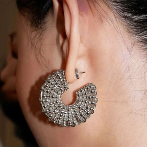 Statement silver C-shaped disk earrings with dense metallic bead texture and stud back