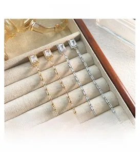 Gros plan de boucles d'oreilles élégantes à longues franges avec cristaux de zircon rectangulaires