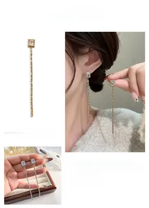 Détails de boucles d'oreilles à pampilles longues avec zircons carrés en or et argent