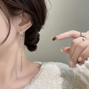 Gros plan d'une boucle d'oreille longue à pampille avec zircon sur un mannequin