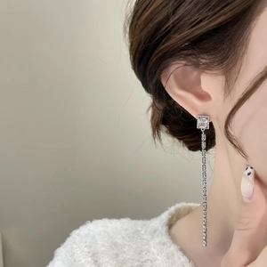 Vue macro de boucles d'oreilles pampilles en argent avec zircons carrés