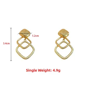 Detail view of gold geometric drop earrings with 3.4cm length and 4.9g weight specifications