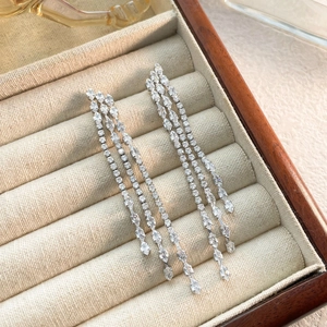 Close-up of long silver tassel earrings with marquise and round cubic zirconia in a jewelry box