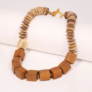 Handmade beaded wood necklace with square beads and gold accents on a white stand