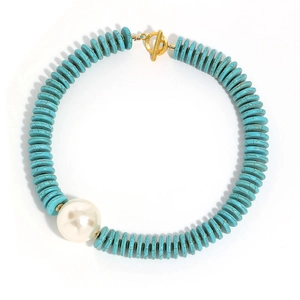 Bohemian turquoise and pearl necklace with golden OT clasp on white background