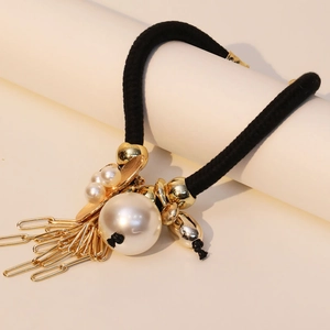 Collier élégant en corde tressée avec perles et pompons dorés sur socle blanc