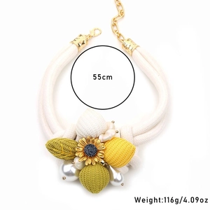 Handgefertigte Sonnenblumen-Halskette mit weißen Perlen und grünen Blättern im Boho-Stil