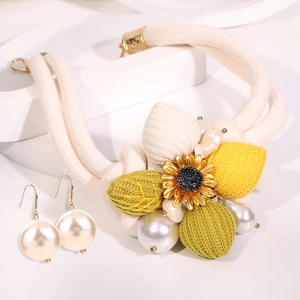 Detail der handgefertigten Boho-Sonnenblumenkette mit Perlen und passenden Ohrringen