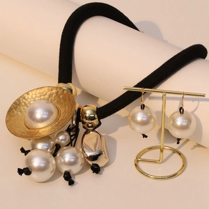 Close-up of elegant pearl necklace and matching earrings on a gold display stand