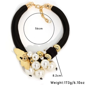 Multi-strand black cord necklace with faux pearls and gold butterfly wing pendant