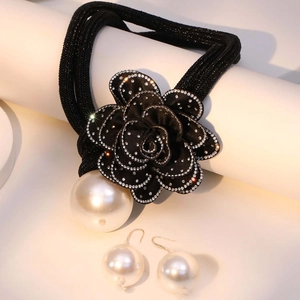Detailed close-up of camellia flower necklace with crystal edges and round pearl drop
