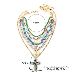 Détail du collier bohème multicouche avec pendentif croix et perles turquoise