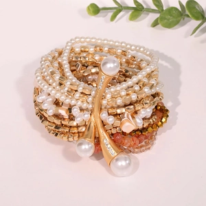 Multi-layer faux pearl bracelet set with gold cubes and red beads on pink background
