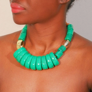 Detail of chunky green resin beaded necklace with marble texture and gold metal accents
