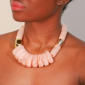 Close-up of peach resin chunky necklace with marble texture and gold metallic accents