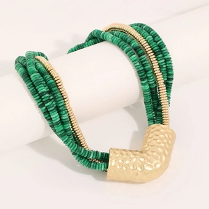 Detail of layered green beaded necklace featuring a large hammered gold V-shape pendant