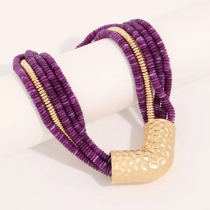 Close-up of bohemian multilayer purple disc beads with a hammered gold V-pendant