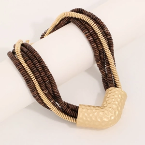Detailed view of bohemian layered beaded necklace with large gold hammered V-pendant