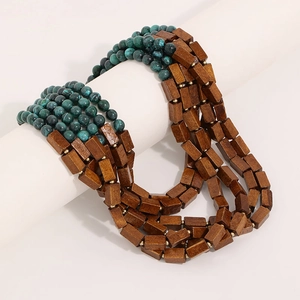 Bohemian multi-layer necklace with turquoise beads and brown wooden blocks on white stand