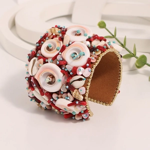 Handmade bohemian cuff bracelet with natural shells and red coral stones decoration