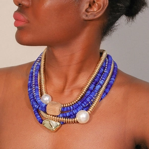 Détail d'un collier multicouches avec perles bleues, perles et pendentif coeur doré