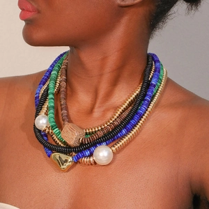 Détail d'un collier bohème multicouche avec perles blanches et pendentif coeur doré