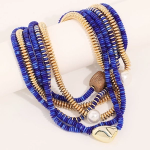 Détail d'un collier bohème multicouche avec perles bleues et pendentif coeur doré