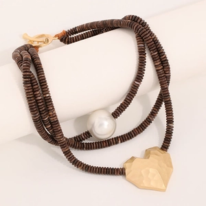 Beaded wooden necklace featuring a large pearl and hammered gold heart pendant
