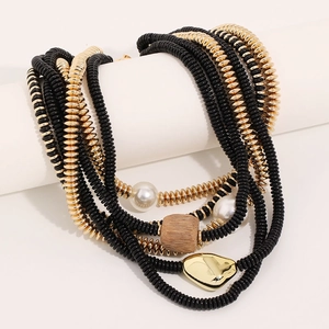 Détail d'un collier multicouches perlé avec pendentif coeur doré et perles d'imitation