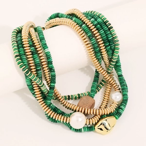 Détail d'un collier bohème multicouche avec perles vertes et pendentif visage doré