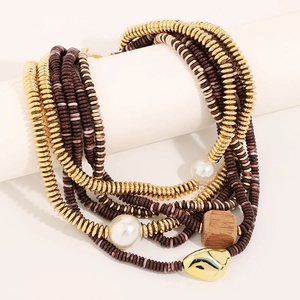 Détail d'un collier bohème multicouche avec perles blanches et pendentifs dorés
