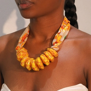 Bohemian large yellow resin bead necklace with floral fabric ties on a model