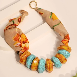 Detail of bohemian necklace with floral silk ribbon and faux turquoise resin beads