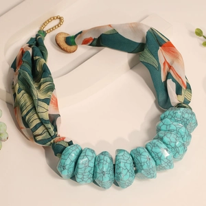 Close-up of bohemian fabric necklace with turquoise resin beads and tropical floral print