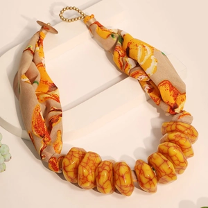 Detailed close-up of bohemian fabric floral necklace with yellow marbled resin stones