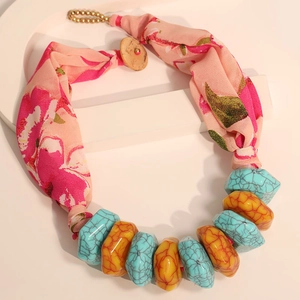Detail of bohemian printed fabric necklace with turquoise resin beads and wood button