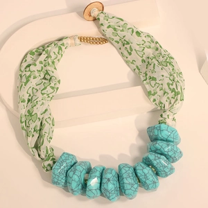 Detail of bohemian fabric necklace with turquoise-style resin beads and heart-print cloth