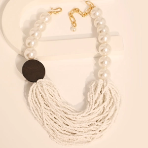 Detail of layered bohemian necklace featuring faux pearls and intricate white seed beads