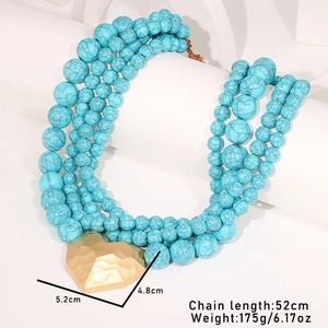 Détail du collier de perles turquoise multicouche avec grand pendentif cœur doré