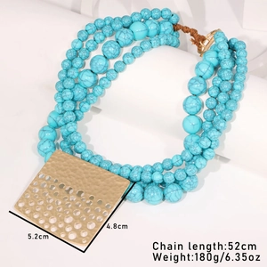 Détail du collier de perles turquoise avec pendentif doré martelé et dimensions affichées
