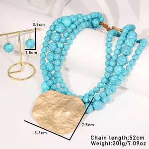 Vue détaillée du collier bohème en perles de turquoise avec pendentifs dorés martelés