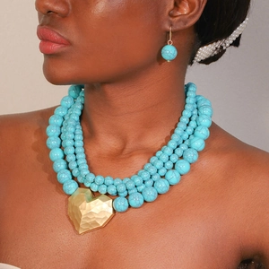Collier multicouche en perles de turquoise avec un grand pendentif cœur doré et boucles d'oreilles