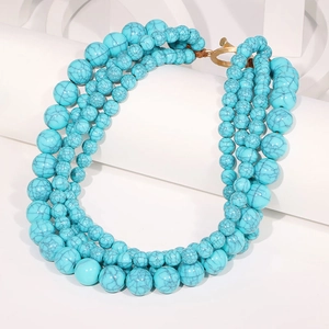 Détail d'un collier à quatre rangs de perles turquoise avec fermoir en T doré